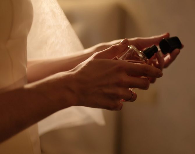 The bride holds a perfume in her hands. Close-up. Wedding prepar